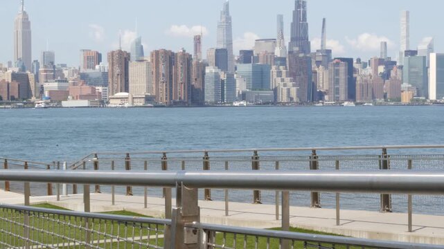 Manhattan Midtown skyline, Edge Park ferry pier promenade, North Williamsburg, New York City USA. East River waterfront, Brooklyn. Financial district skyscrapers architecture. Riverfront cityscape.