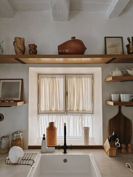 Bright rustic kitchen with wood accents, soft natural light, warm Mediterranean aesthetic and clean minimal style