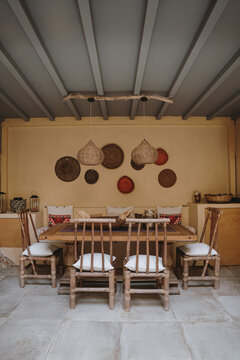 Rustic outdoor dining area, rattan chairs and warm natural tones, cozy Mediterranean-inspired patio design