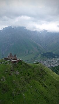 Gergeti Trinity Church with dramatic clouds and Caucasus Mountains in Georgia