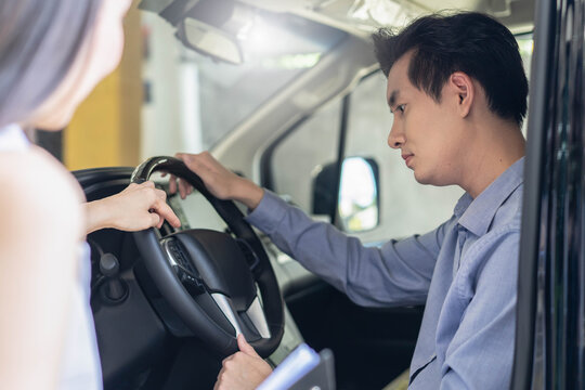 Woman car salesperson showing finance contract to client and explain deal in auto showroom