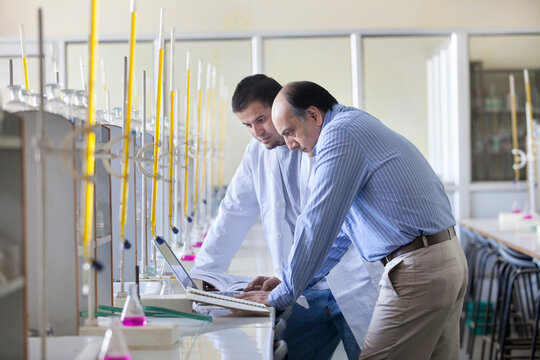 Professor and student looking at laptop