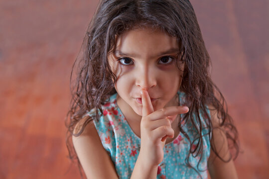 Portrait of girl with finger on lips