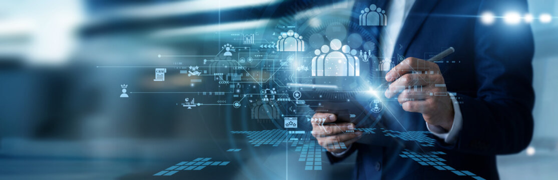 Sales executive working on tablet updating corporate CRM databases, tracking customer engagement history, managing client pipelines, and maximizing sales productivity using CRM software.