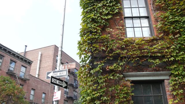 New York City urban residential buildings architecture, Lower Manhattan West village Greenwich street corner, United States of America. Greenwich village, USA. Red brick house. Vine greenery on wall.