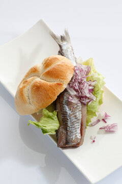 Sandwich stuffed with salted herring in plate