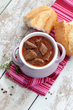 oulash soup with white bread in bowl, close up