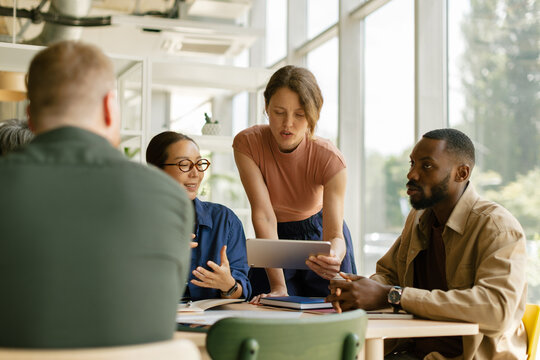 Female boss explains new business plan to her team in the office