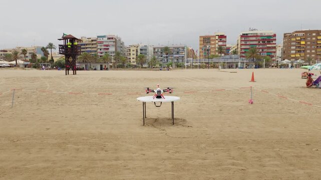 Rescue drone on sandy beach for emergency response and swimmer safety. Lifeguards monitoring recreation area near shoreline. Modern technology for drowning prevention and coastal rescue operations