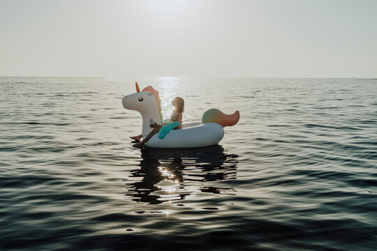 Woman floats on an inflatable unicorn in the Mediterranean sea
