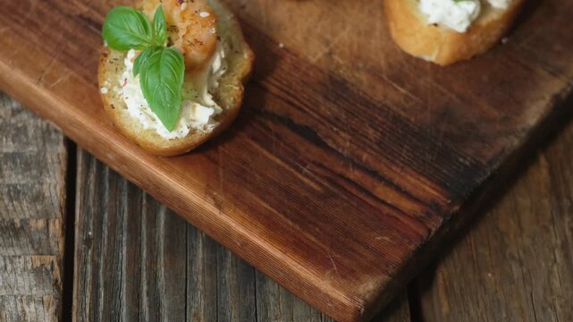 Woman eating bruschetta with cream cheese, shrimp and fresh basil. Healthy snacks, breakfast.