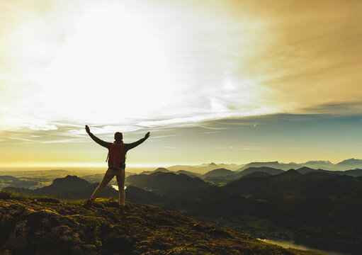 Hiker reaching summit cheering with arms raised