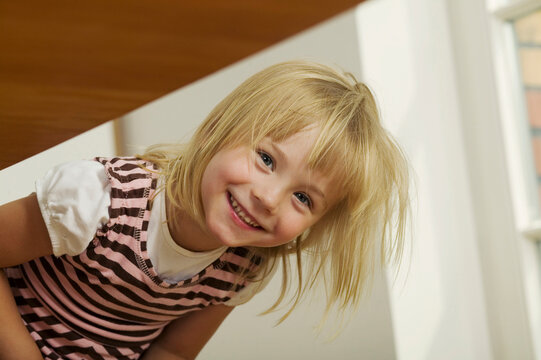 Girl (4-5) leaning forward, portrait, smiling