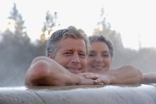 Mature couple relaxing in outdoor spa, portrait