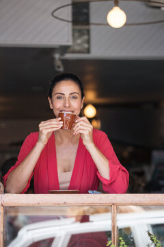 Mature woman sitting in cafe, drinking coffee