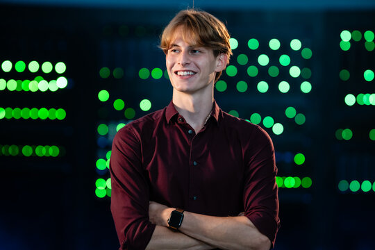 Young smiling man in server room representing technology success