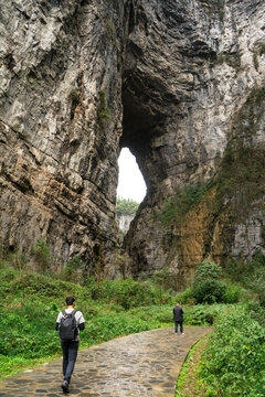 Tourist walk to see view of a huge cave hole scenery at Tianlong Bridge, the first natural stone bridge of Three Natural Bridges in Wulong Karst National Geology Park, a UNESCO World Heritage Site in 