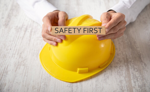 Man showing Safety First text on wooden block.