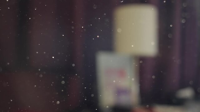 Dust particles flying in the air in dusty dirty stuffed room in house or apartment. Old and closed interior. Sunlight shining through making specks of dust visible. Moving and floating by in close up