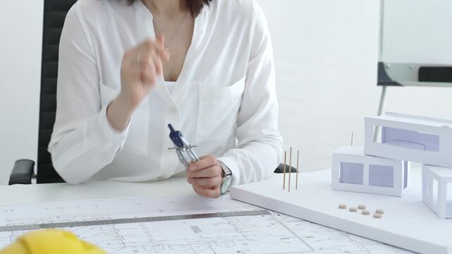 Architect hands working on building blueprint, analyzing design with scale model structures, developing urban planning and innovative construction project ideas