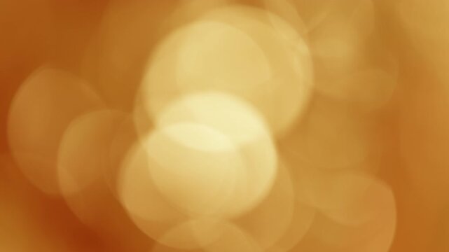 Large golden-amber bokeh circles shimmering and flickering in evening wind, relaxing nature background
