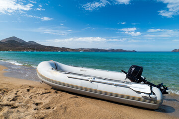 Inflatable boat on a sandy beach with turquoise water on Milos island © Lukasz