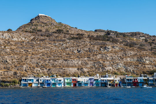 Seaside village at the foot of a rocky hill with waterfront houses on Milos