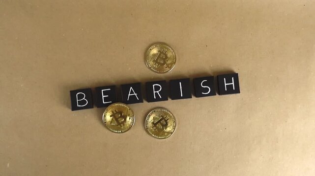 Golden bitcoin coins surrounding black tiles spelling bearish, symbolizing a cryptocurrency downtrend, financial crisis, investment risk, and the volatility of the digital currency market