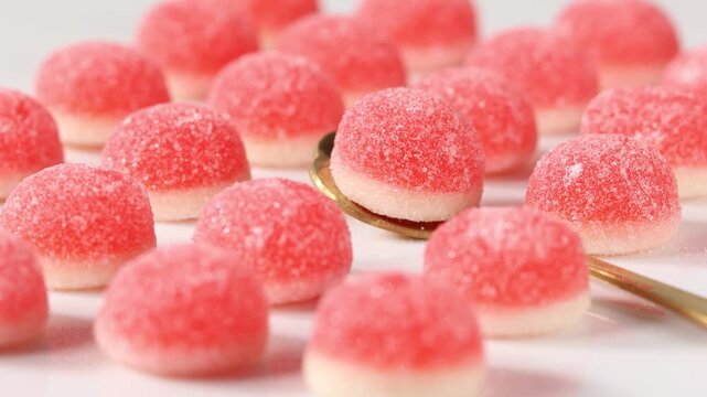 Close up of pink gummy candies with sugar coating in moody still life style