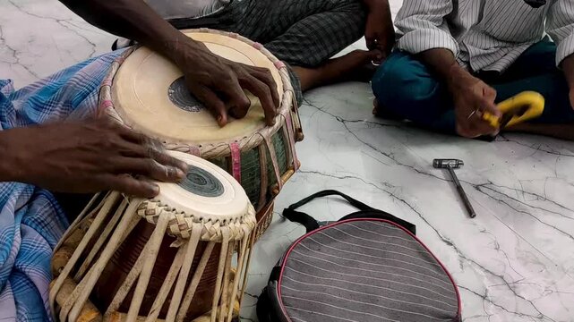 Close-up video of a musician playing a pair of traditional Indian tabla drums. The detailed drumheads, black syahi centre, and hands highlight this classical music, South Asian culture and percussion.