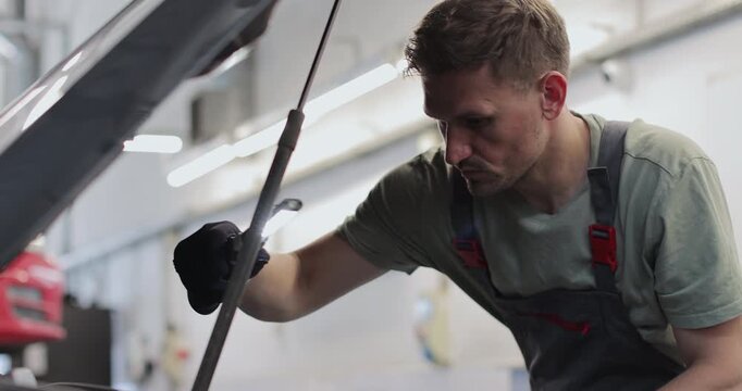 Mechanic man with lamp working at workshop. concept car service, repair, maintenance and people.