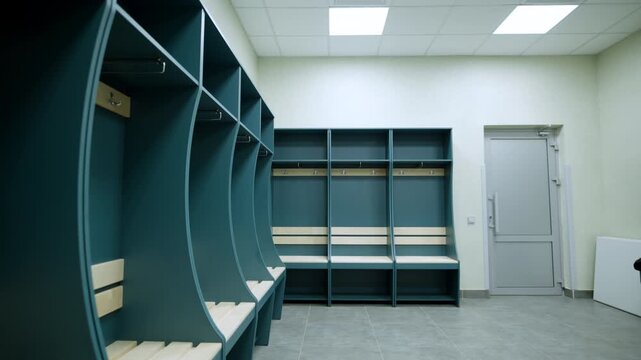 Continuous rows of curved open teal lockers stretch through modern changing space. Matching wooden benches are seamlessly integrated