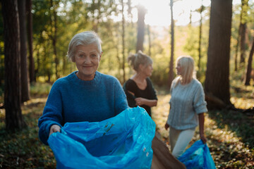 Obraz premium Senior women volunteering for nature protection and litter collection.