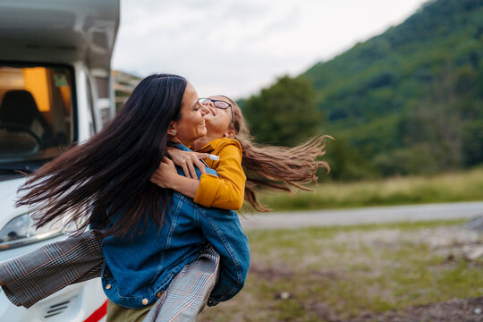 Mother with daughter enyoing family holiday with camper and caravan.