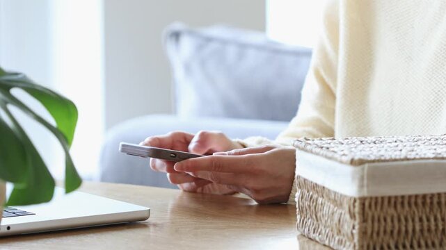 Digital detox from gadgets, social media and technology addiction with woman  at home workplace closing laptop and putting away phone in basket for healthy lifestyle and mental health.