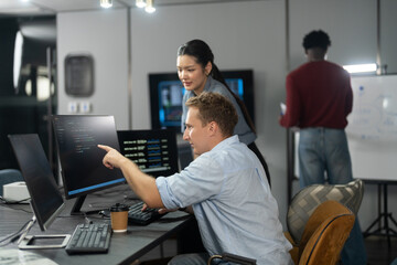 Fototapeta premium Diverse male and female programmers teamwork coding collaboration in modern IT office, Happy software developer team analyzing data on computer monitors, Technology business startup innovation