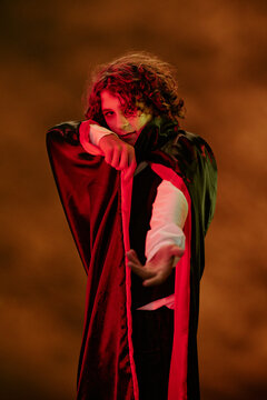 Portrait of Caucasian teenager boy wearing vampire costume celebrating Halloween. Image suitable for seasonal marketing campaigns and festive event promotions, vertical