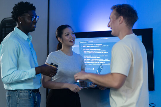 Diverse software developer team collaborating on computer code in modern IT office, Male programmers and female colleague brainstorming future technology business innovations and smart digital system
