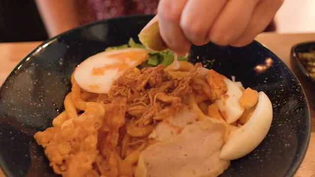 Squeezing Fresh Lime Over Burmese Nan Gyi Tote Noodle Salad