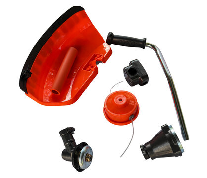 Spare parts for an orange string trimmer lawnmower are laid out on a white background. The set contains a protective guard, a metal handle, a trimmer head, and a gear head.