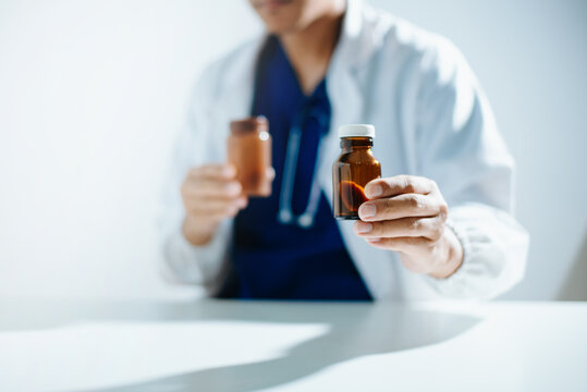 A healthcare professional holding and explaining a prescription medicine bottle.