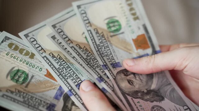 Close up hands counting stacks of United States 100 dollar bills banknotes after get paid. Person calculates cash, income, salary, profit, want to buy something.