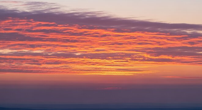 Vibrant Sunset Sky with Fiery Orange and Purple Clouds.