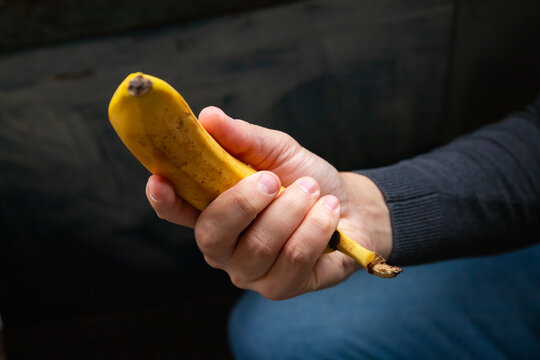 Man holding banana as a symbolic metaphor for sexual health. Conceptual representation of male erectile dysfunction, potency, libido and urological examination. Men medical care concept.