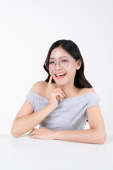 Fototapeta premium Cheerful young Asian woman smiling with finger touching cheek and wearing glasses on white background.