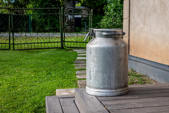 Vintage Aluminum Milk Can on Wooden Steps at a Rural Farm