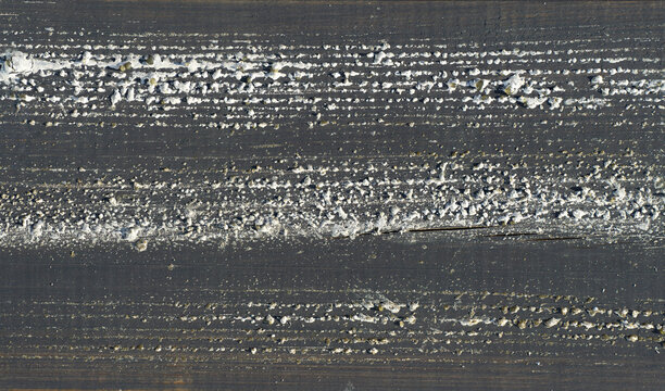 Dark weathered wooden surface with peeling white paint and crusty texture. background, timber, old wood surface, closeup view, peeling paint.