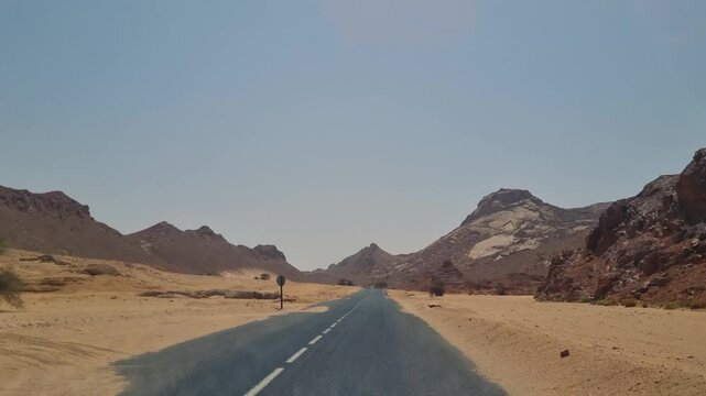POV drive through the immense Sahara Desert near Djanet, Algeria, revealing endless sand dunes, open desert landscapes and the solitude of one of the world's largest deserts