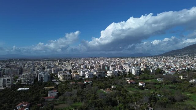 Aerial left slide, raise up shot, Kalamata cityscape , beautiful clouds on blue sky on a winter day 4K