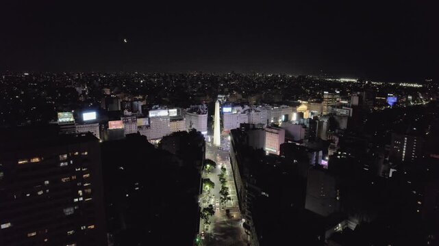 4K drone aerial view of the Obelisk and Corrientes Avenue in Buenos Aires, Argentina at night. The city&rsquo;s most iconic landmark surrounded by illuminated streets and vibrant urban life.